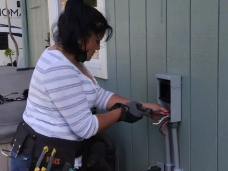 Licensed electrician wiring an exterior subpanel in Plainview